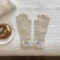 Kuschelige Strick-Fingerhandschuhe Detailansicht mit Rippbündchen und schickem Label. - 28x11cm / Elfenbein
