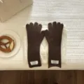 Nahaufnahme gemütlicher dunkelbrauner Winter-Strickhandschuhe im stilvollen Flat-Lay-Stil. - Kaffeebraun