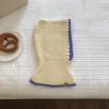 Close-up detail of knitted balaclava in cream and purple contrast trim, cozy winter flat lay. - Ivory