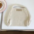 Nahaufnahme einer minimalistischen cremeweißen Strickhandtasche, weiche Textur für den Alltag. - 31x26cm / Gebrochenes Weiß