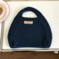 Klassisches Detail einer dunkelblauen Strickhandtasche mit weicher Textur für den Alltag. - 31x26cm / Marineblau