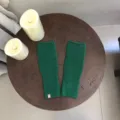 Detailaufnahme dunkelgrüner Strick-Fingerless-Handschuhe, kuschelige Wolle mit Rippbündchen. - Grün