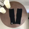 Nahaufnahme schwarzer Strick-Fingerlose Handschuhe mit feiner Rippstruktur im Detail. - Schwarz