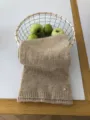 Detailansicht eines gemütlichen, beigen Strickschals mit Rippsaum und metallic Akzent. - Khaki