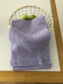 Detailansicht eines kuscheligen Lavendel-Strickschals mit weicher Textur und feinem Metallelement. - Hellviolett