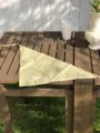 Detailansicht des karierten Dreiecktuchs mit feinem Muster auf Holztisch präsentiert. - Gelb