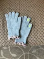 Grey knit gloves detail showing pink ruffle cuffs and cute finger embroidery, soft winter. - Light Gray
