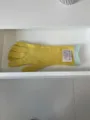 Detaillierte Nahaufnahme gelber, langer Strickhandschuhe mit grünen Bündchen und Markenschild. - Gelb