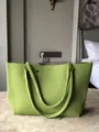 Gros plan d'un sac cabas en tricot vert uni, mettant en valeur son tissu texturé. - L / Vert