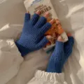 Blaue Strick-Halbfingerhandschuhe Detailaufnahme mit weicher Textur für den Winter. - Blau
