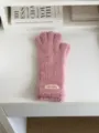 Detail view of pink fuzzy winter touchscreen gloves, soft plush texture close-up on desk. - 27X10CM-W207MD / Pink