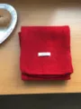 Nahaufnahme eines kuscheligen roten Winterschals aus 100% Wolle, weiche warme Stricktextur. - Rot