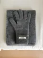 Vista detallada de guantes y bufanda de punto de lana gris con textura suave y cálida. - 26x12cm / Gris