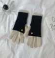 Detailed view of contrast color knit gloves featuring black and beige design with elegant buttons. - 24x12cm-W205P / Ivory