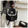 Vue détaillée du sac à dos noir imprimé d'étoiles avec bordure en dentelle blanche et cordon. - Noir