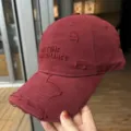 Vue de détail d'une casquette de baseball en coton lavé avec broderie et effet usé. - Bordeaux