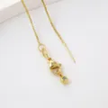 Gold box chain necklace detail view with lobster clasp and extension component. - Pin Box Chain