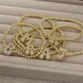 Nahaufnahme Detail des Goldperlen Armbands mit klobigen glitzernden Zirkon Buchstaben Anhängern. - Buchstabe A / Gold Armband