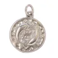 Close-up detail of vintage round Pisces zodiac pendant, silver tone metal craft accessory. - Pisces