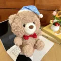 Cute brown plush teddy bear toy with blue polka dot sleeping hat and red bow tie for desktop. - Warm Brown Bear - Red Bow