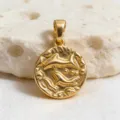 Detailed close-up of a vintage gold-plated coin pendant featuring an intricate dolphin relief design. - Pisces