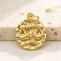 Close-up detail of vintage gold-plated zodiac coin pendant showing exquisite relief texture. - Libra
