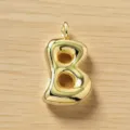 Vista detallada de un colgante con letra B dorada y abultada, abalorio inicial brillante y elegante. - Letra B / Dorado