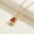 Detalle de collar con colgante de niña de oro con cuerpo de piedra roja y cabeza brillante. - Niña-Enero