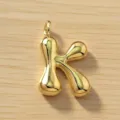 Colgante de letra K abombada dorada en detalle, elegante abalorio metálico inicial. - Letra K / Dorado