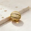 Gros plan d'une perle charm de basket-ball plaquée or, surface pavée de zircone cubique. - Style 1