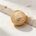 Détail en gros plan d'une perle pendentif basket en plaqué or avec zirconiums et émail rose. - Style 2