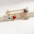 Gold evil eye safety pin pendant detail, featuring enamel charms and sparkling rhinestones. - Style 2 (Pendant)