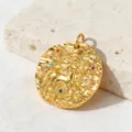 Primo piano del ciondolo zodiacale dorato intarsiato con zirconi colorati su pietra. - Stile 9 (ciondoli)