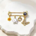 Gold evil eye safety pin pendant with multiple charms like butterfly, star, and flower. - Style 5 (Pendants)
