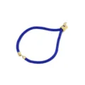 Primo piano dettaglio del bracciale in corda di nylon blu intrecciato con cursori dorati. - Blu scuro