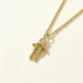 Primer plano de un collar con colgante de personita chapado en oro con piedra verde. - Niño-Noviembre