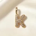 Vergulde letter K hanger sieraden detail close-up, prachtig stralend mode accessoire. - Letter K