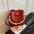 Red woven leather bucket bag for women, retro shoulder crossbody handbag with chain strap. - Red