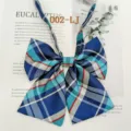 Close-up detail of blue and turquoise plaid JK uniform bow tie with fine ribbon and strap. - 002-LJ