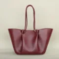 Primer plano detallado del bolso tote plisado rojo vino con correas dobles y anillos de metal dorado. - 28062# rojo vino