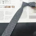 Detailed view of gray plaid narrow tie, classic retro style for business and casual wear. - Gray Plaid