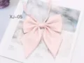 Detail view of a shiny pink JK uniform bow tie with pointed big wing design and ribbon. - Light Pink