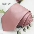 Detailed view of a solid pink necktie, stylish fabric texture, perfect for formal business attire. - Pink