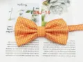 Detailed view of an orange polka dot bow tie, classic double-fold design for formal wear. - SNJ-16