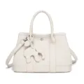 Women's off-white leather tote bag shoulder crossbody handbag with cute elephant charm accessory. - Milky White