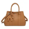 Brown leather tote bag with top handles, shoulder strap and cute elephant charm accessory. - Tan