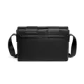 Bolso bandolera de piel negra con solapa tejida ancha, estilo moderno y minimalista. - Negro