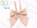 Detailed close-up shot of a sparkling pink JK uniform bow tie with long ribbons. - Nude Pink