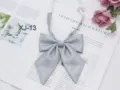 Close-up detail of the grey sparkling JK bow tie, featuring sharp corner design for school uniforms. - Gray