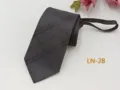 Detailed view of the dark grey plaid men's zipper tie, showing texture and precise tailoring. - Ginger Yellow